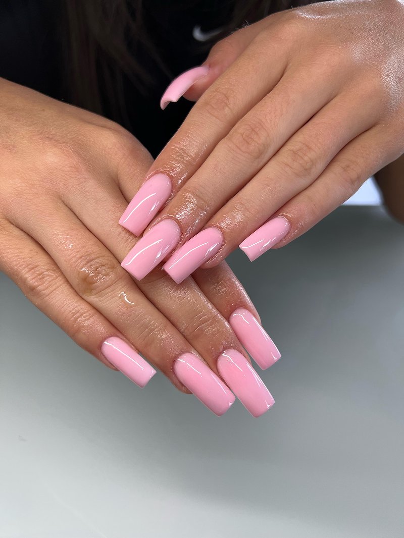 Lange roze acrylnagels in een strakke vierkante vorm, werk van Avista